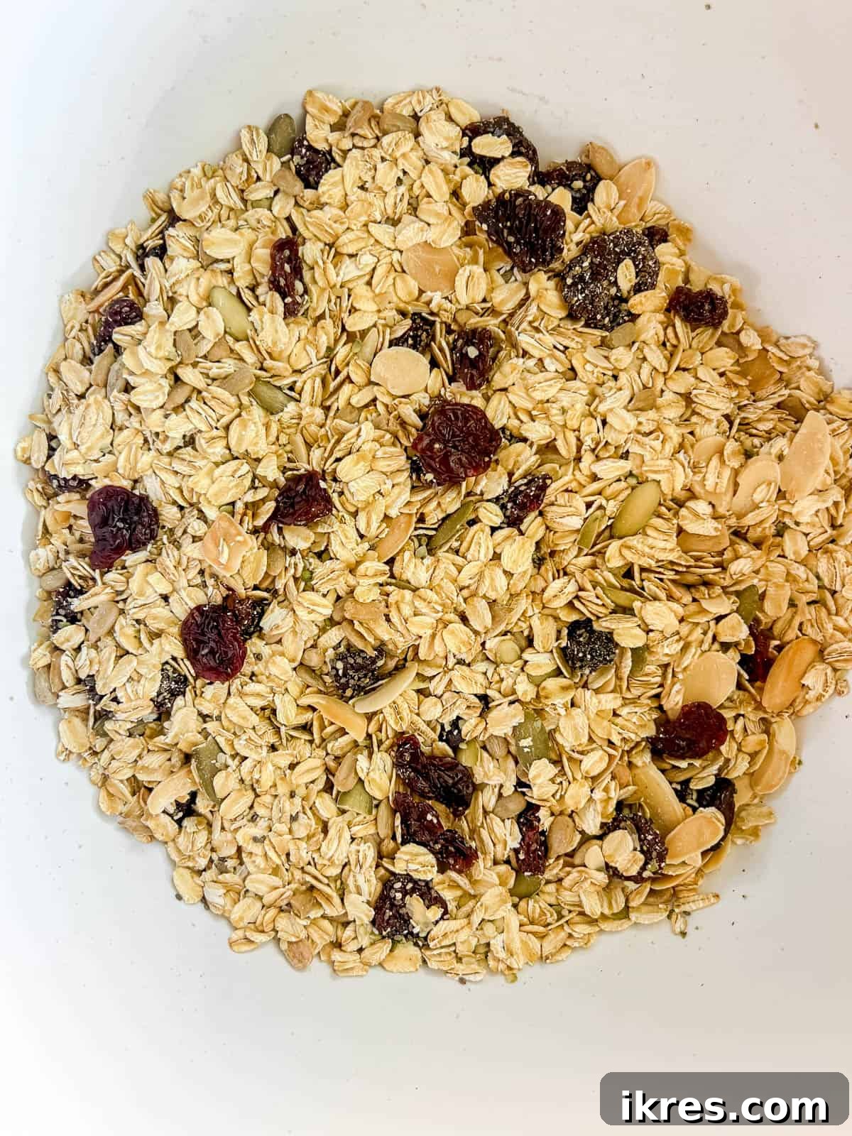 Quick & Creamy Gluten-Free Almond Butter Energy Bars 4 Dry ingredients like rolled oats, seeds, and dried cherries in a large mixing bowl.