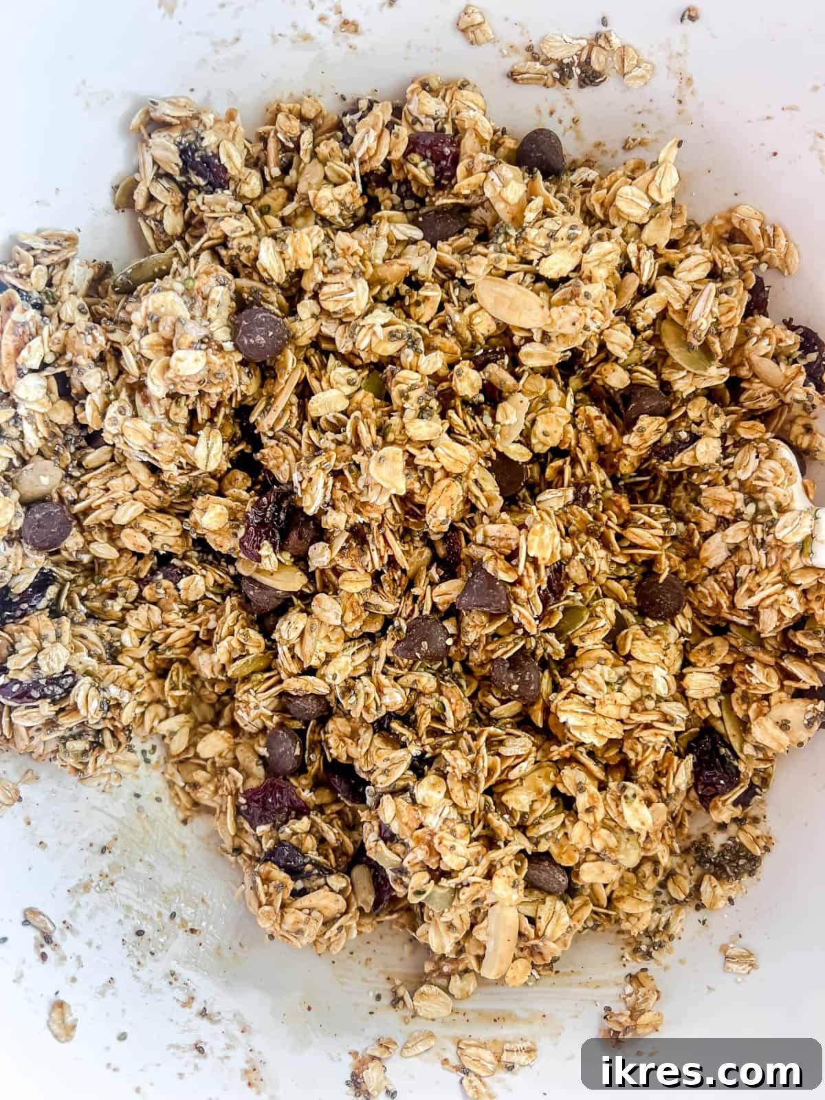 Effortless Gluten-Free Almond Butter Energy Bars 6 Almond butter mixture mixed into oat mixture in a bowl.
