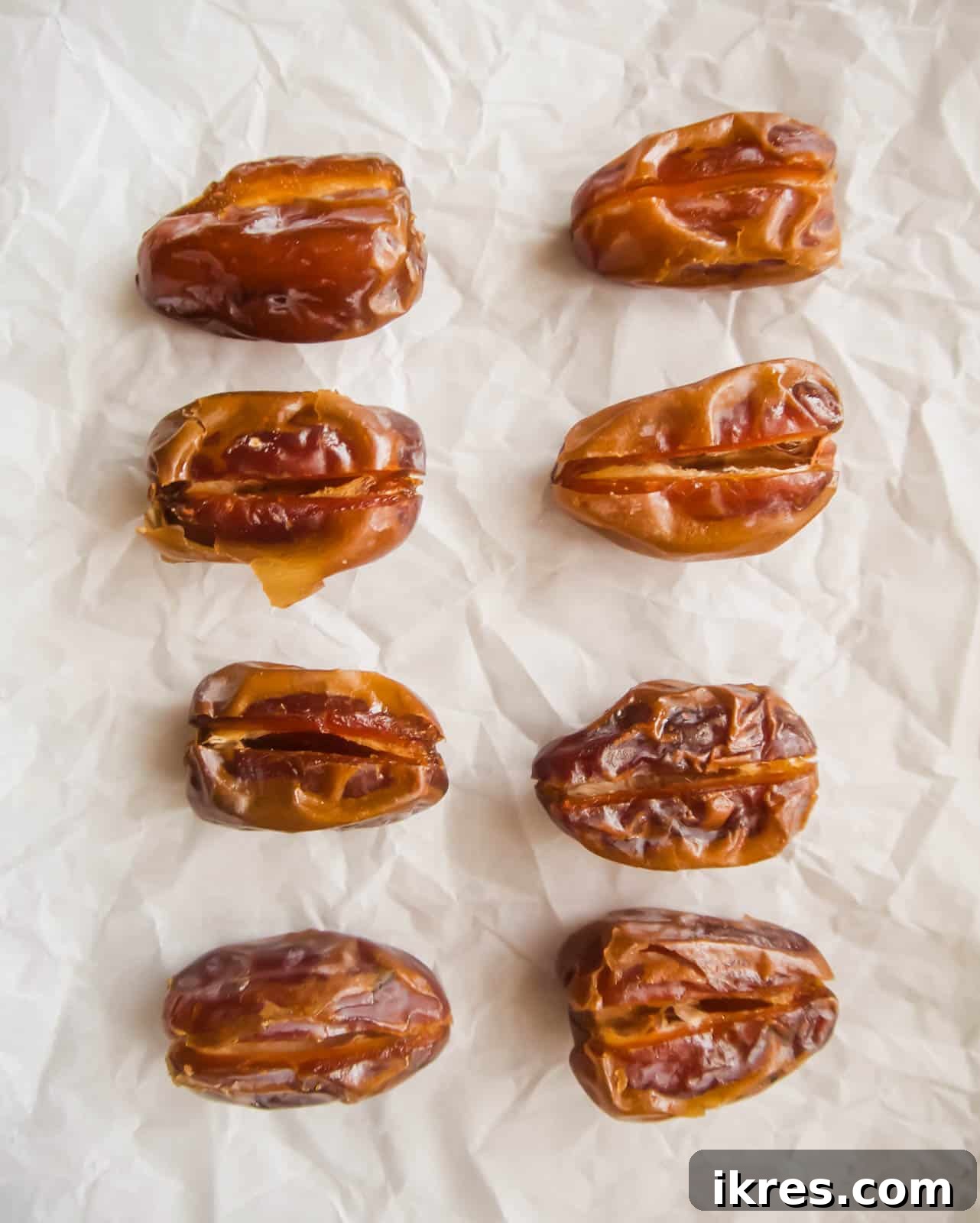 Blissful Bacon Wrapped Raspberry Date Bites 5 Pitted Medjool dates, sliced open lengthwise, lying on a baking sheet, ready to be stuffed.