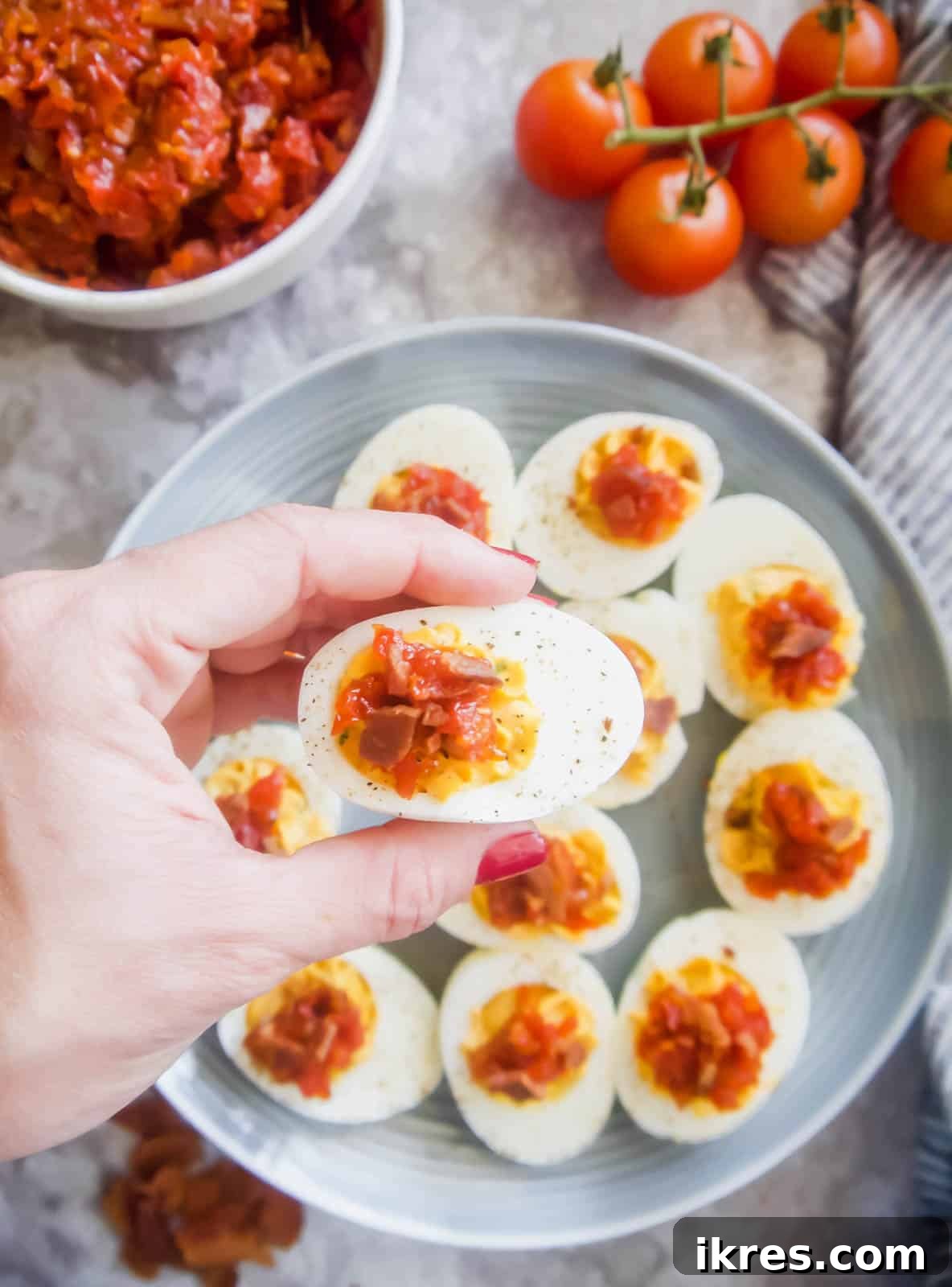 A plate of gluten-free Paleo Deviled Eggs ready to be topped with savory Tomato Bacon Jam.