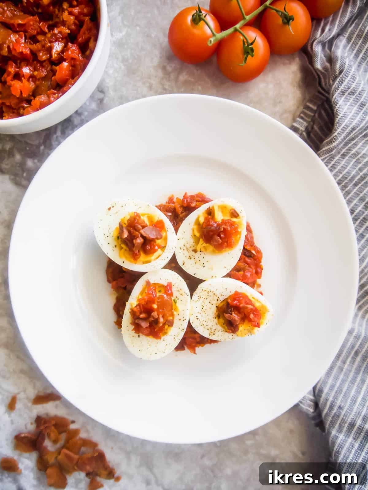 A platter of Paleo Deviled Eggs with Tomato Bacon Jam, perfect for a healthy snack or party food.
