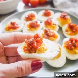 A delicious bite of Paleo Deviled Eggs featuring the unique blend of creamy egg yolk and sweet and savory Tomato Bacon Jam.
