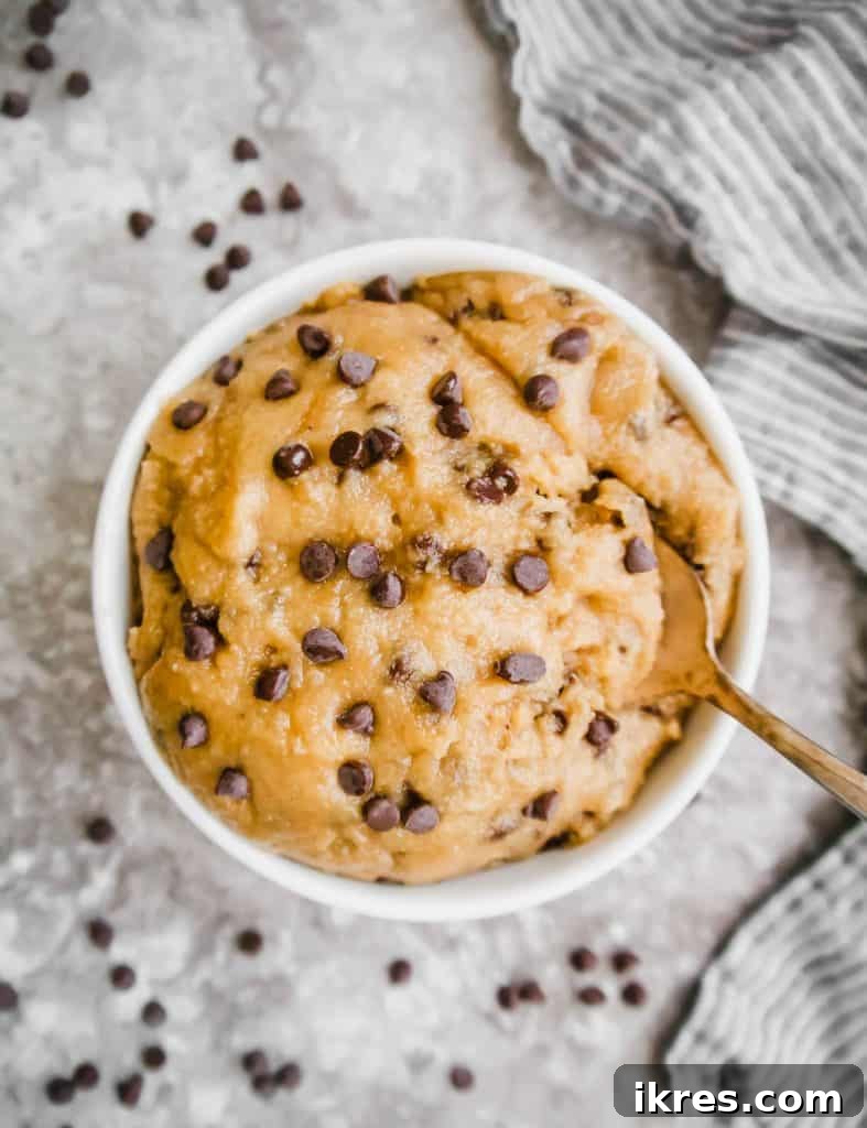 Guilt-Free Gluten-Free Vegan Paleo Cookie Dough 5 Wet ingredients, including light olive oil and maple sugar, being expertly mixed in a bowl with a fork, showing the initial stage of preparing the eggless chocolate chip cookie dough.