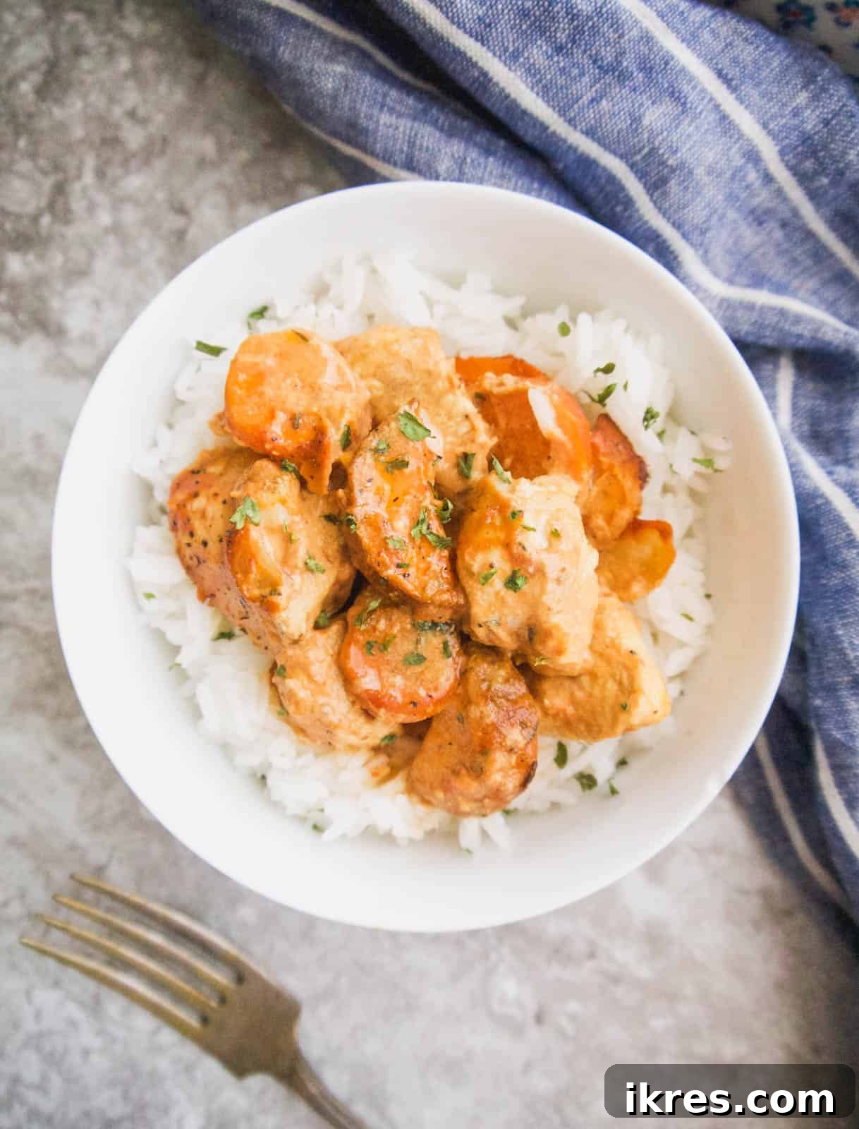 Zesty Dairy-Free Chicken Bake 3 A bowl of creamy mustard chicken casserole with tomato, garnished with fresh herbs, showcasing its rich texture.