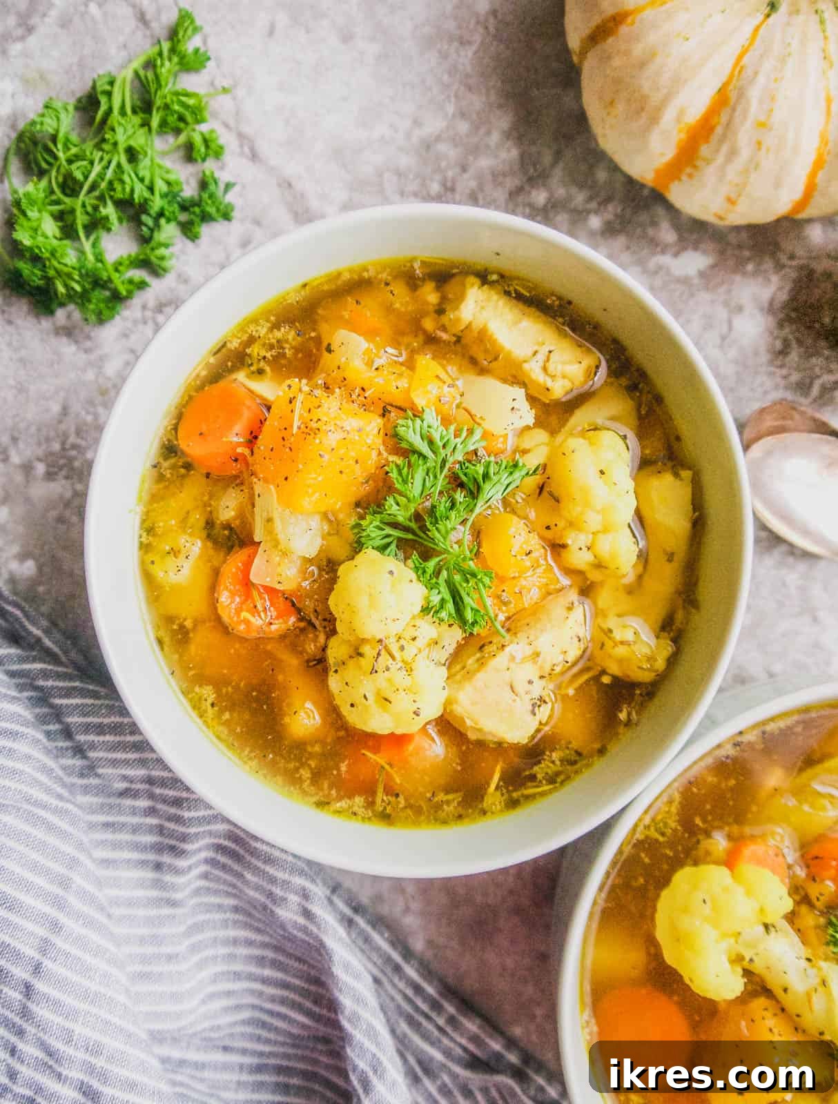 Golden Butternut Chicken Comfort Soup 4 A vibrant bowl of cauliflower chicken soup, showcasing the fresh ingredients and inviting texture.