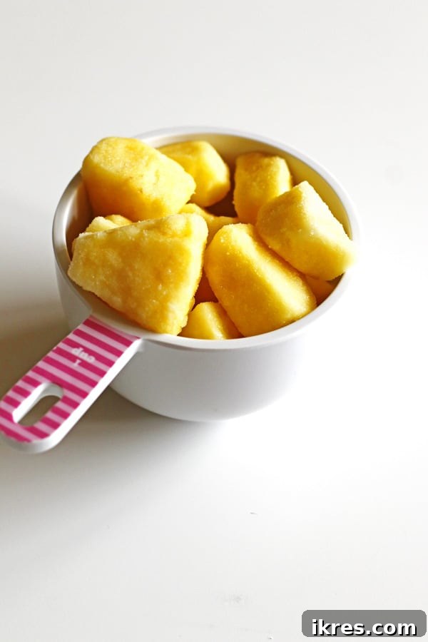 Blended Fruit Bliss 6 Frozen pineapple in a white measuring cup