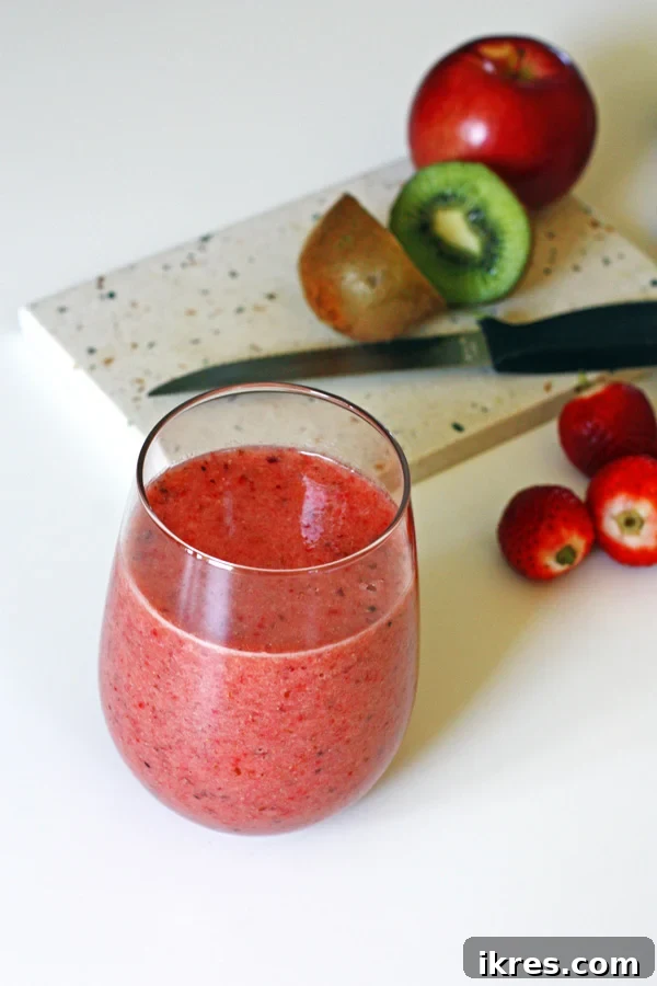 Blended Fruit Bliss 7 Smoothie with sliced fruit on cutting board with a knife