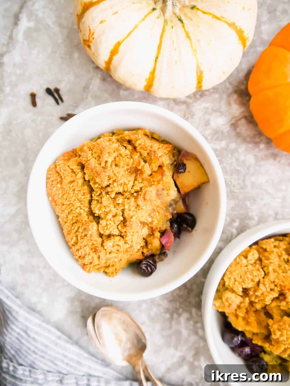 A close-up of Paleo Blueberry Pear Cobbler in a rustic bowl, showcasing the soft cookie topping and fruit filling.