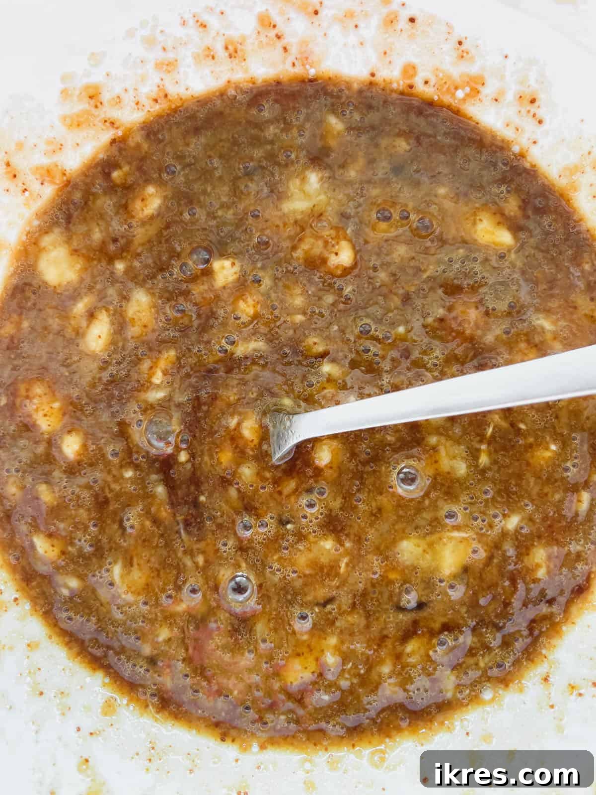 Paleo Banana Bread Grain and Dairy Free 6 Wet ingredients including eggs, vanilla, and mashed bananas mixed in a bowl.
