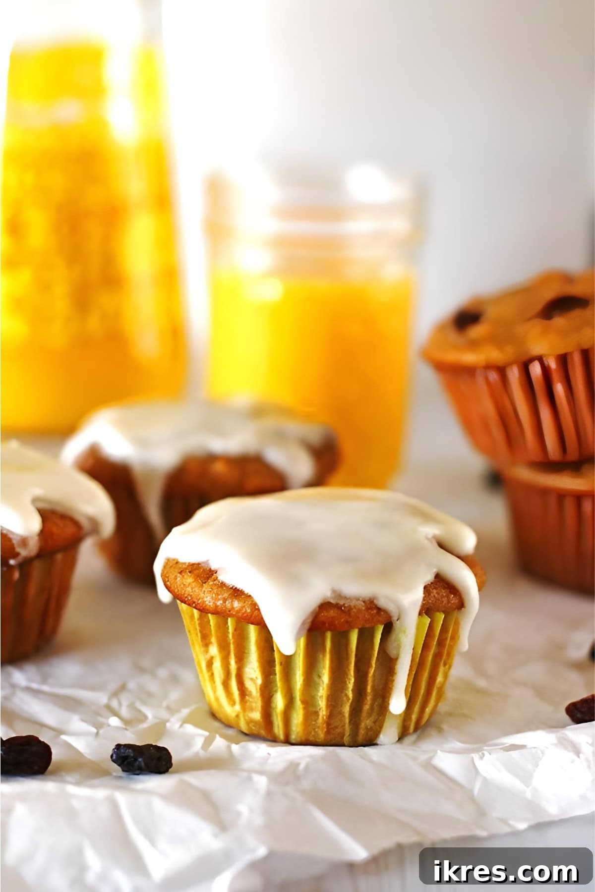 Perfectly Spiced Carrot Cake Muffins with Cream Cheese Glaze 9 Muffins on a table with a glass of orange juice