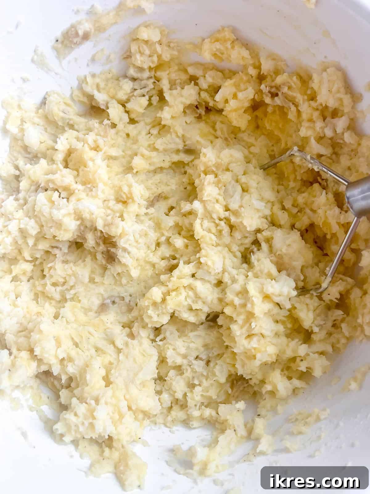 A close-up of fully mashed cauliflower and potatoes in a bowl, showcasing its smooth, creamy, and uniform consistency, ready for serving.