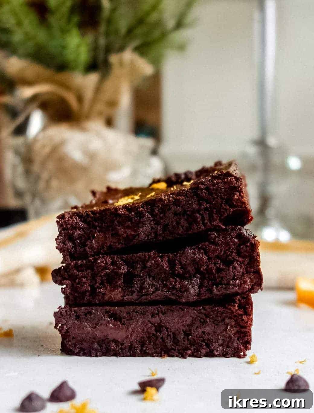 Photo of three delectable chocolate orange brownies stacked neatly on top of each other, showcasing their rich, dark texture and inviting aroma.