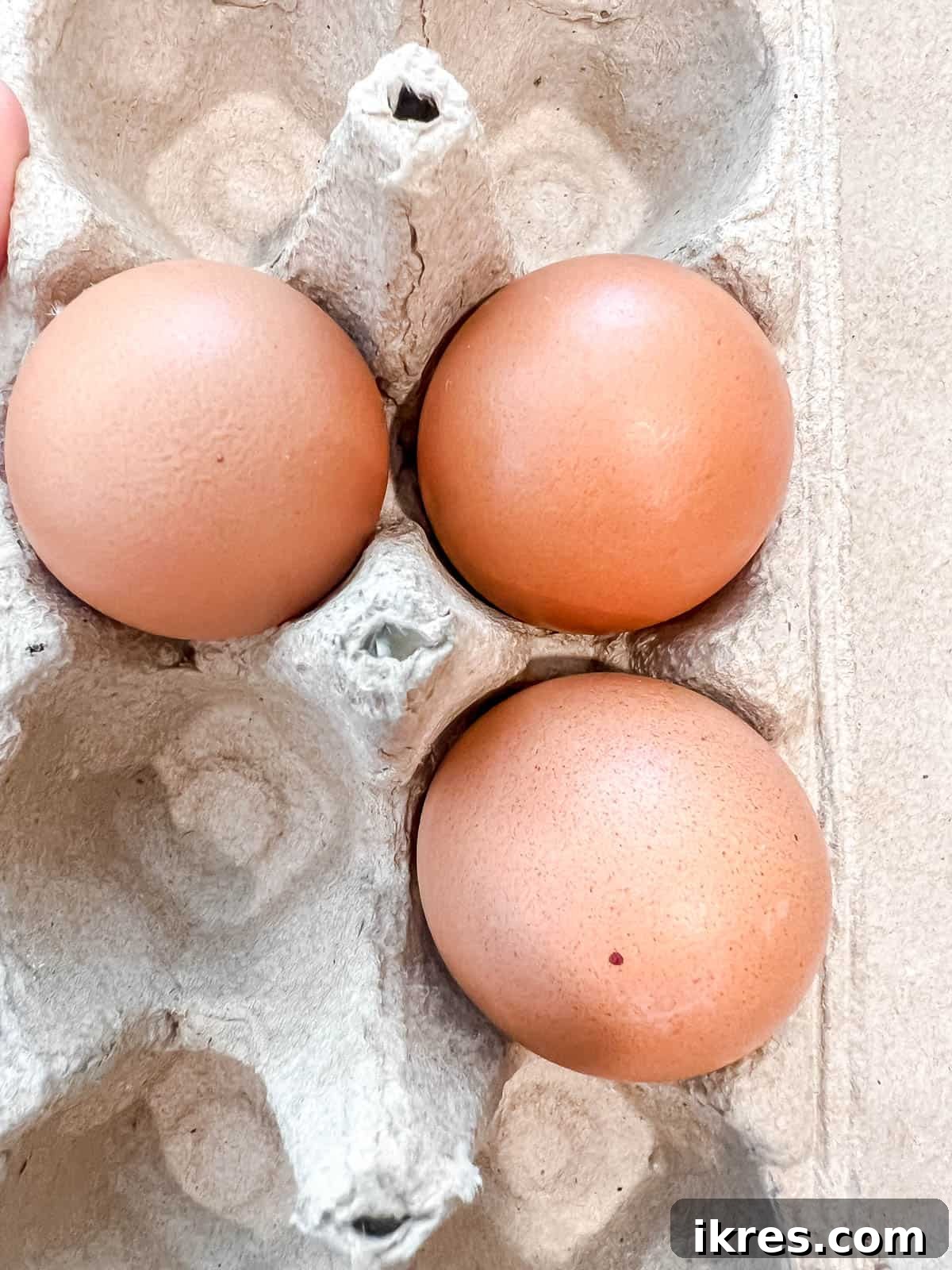 Three eggs, cracked into a bowl, ready for mixing into the meatloaf mixture.