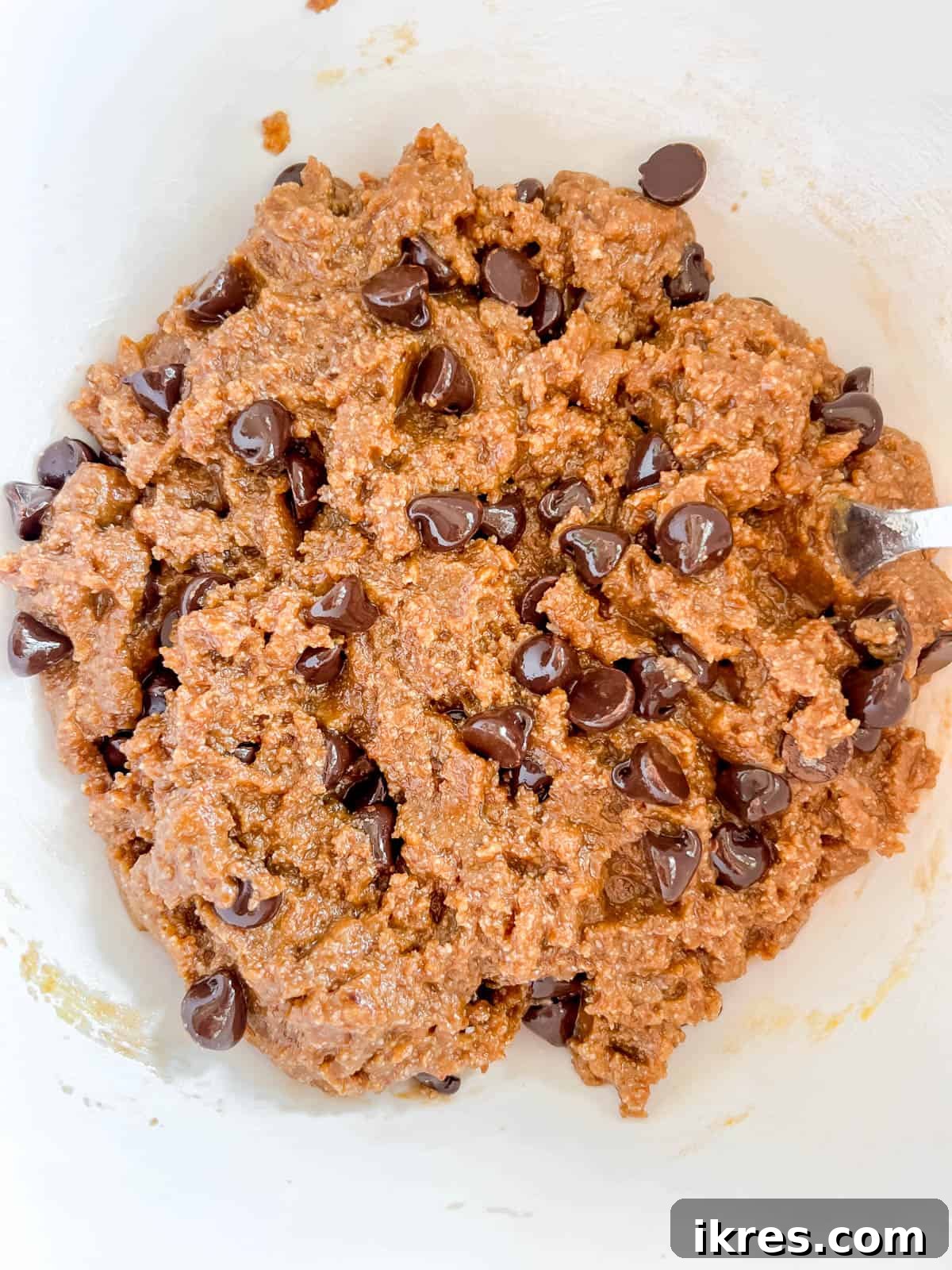 Mixing the cookie bar batter in a bowl, showing a smooth, golden consistency.