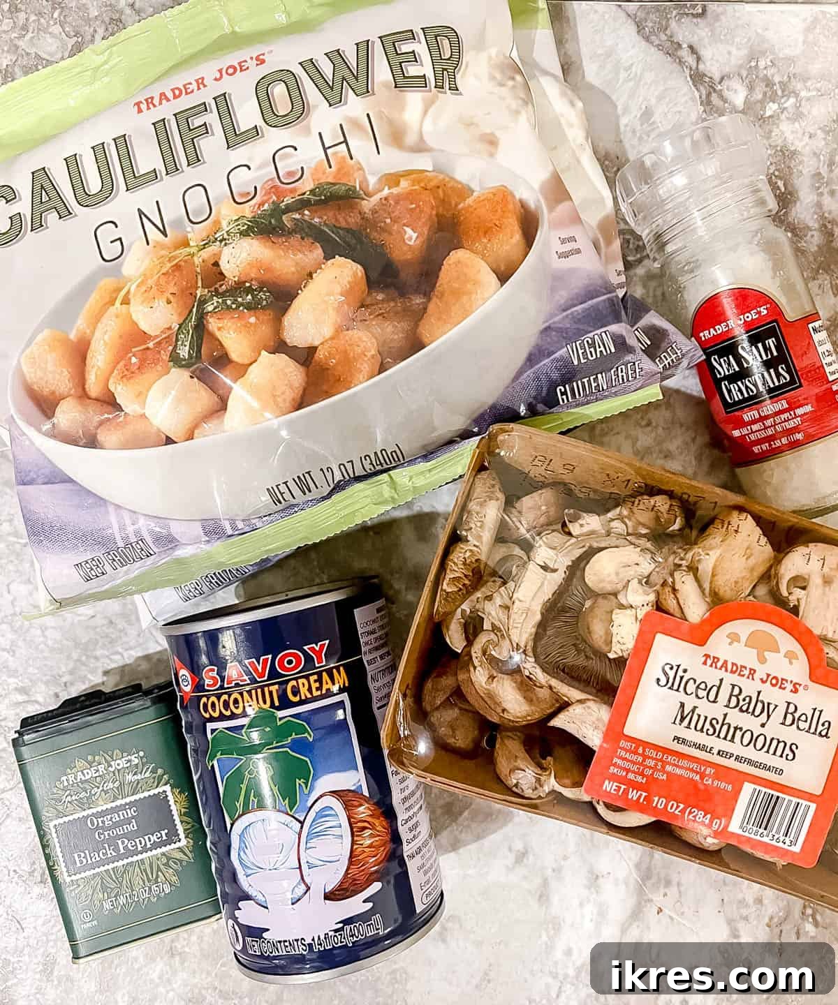Pillowy Cauliflower Gnocchi with Velvety Mushroom Cream 3 Ingredients needed to make cauliflower gnocchi in coconut cream mushroom sauce, including gnocchi, fresh mushrooms, a can of coconut cream, and a pepper grinder.