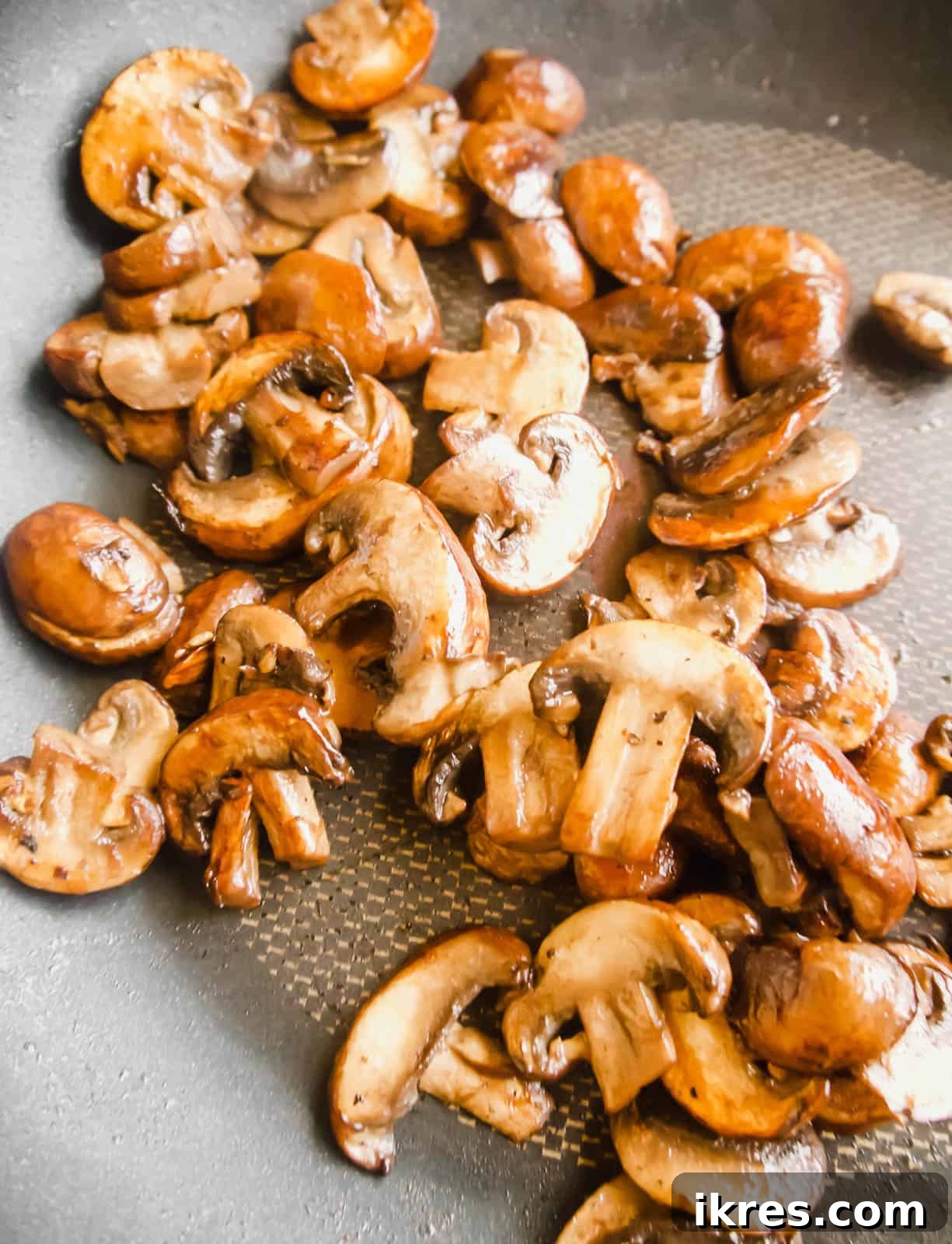 Pillowy Cauliflower Gnocchi with Velvety Mushroom Cream 4 Browned mushrooms in a frying pan, showing their golden, caramelized edges after being cooked undisturbed.