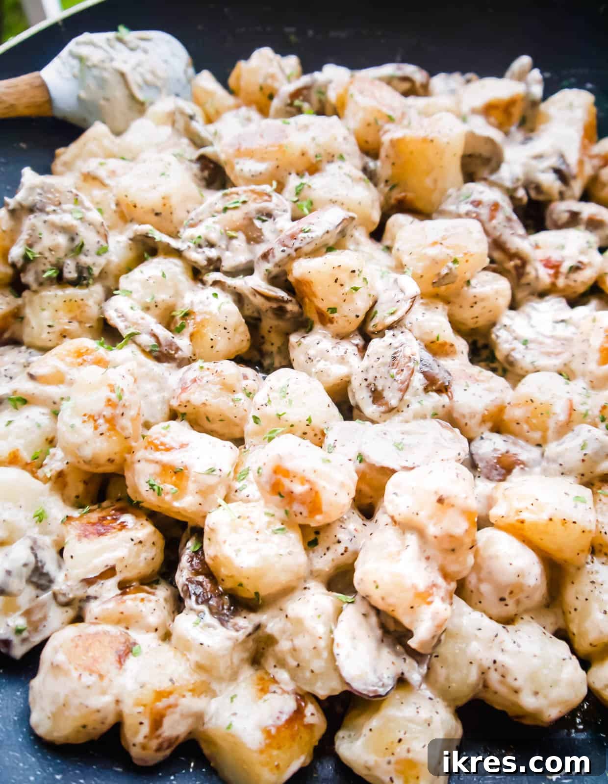 Pillowy Cauliflower Gnocchi with Velvety Mushroom Cream 6 Cooked cauliflower gnocchi being mixed into the mushroom cream sauce in a pan, ready for final serving.
