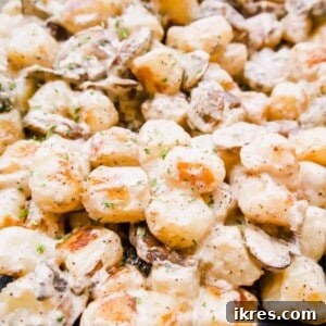 Up close photo of Cauliflower Gnocchi with Creamy Mushroom Sauce in a pan, prepared for serving.