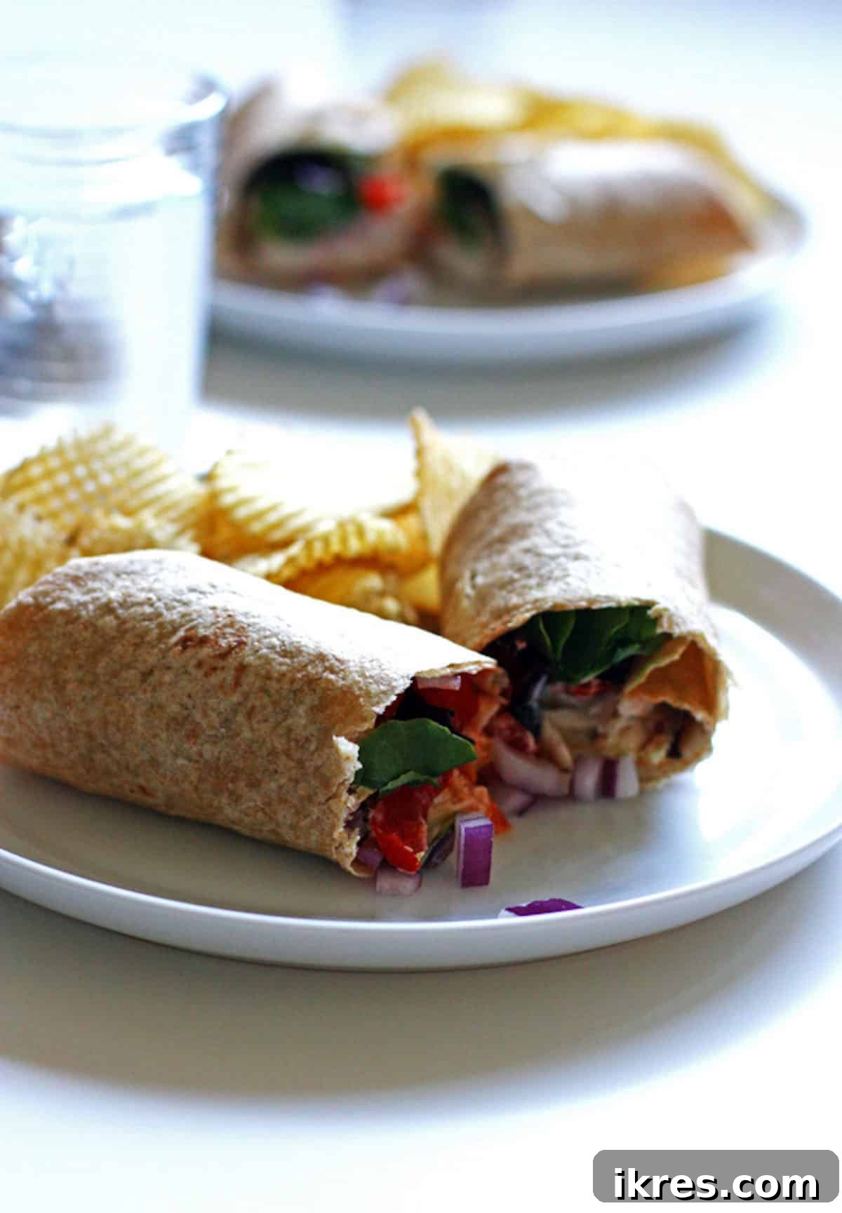 Loaded Ranch Chicken Wraps 2 A chicken wrap with cherry tomatoes, cheese, and onions on a plate, ready to be enjoyed.