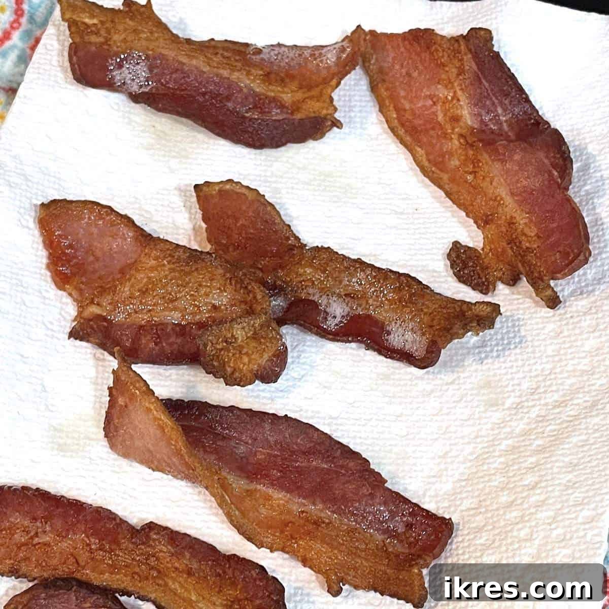 Loaded Ranch Chicken Wraps 3 Crispy air fryer bacon strips cooling on a paper towel.