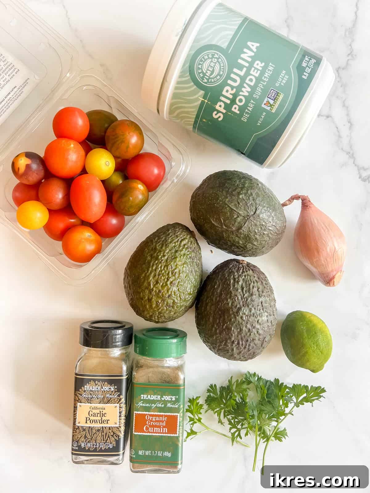 Superfood Spirulina Guacamole 4 Ingredients needed to make Spirulina Guacamole, laid out on a rustic surface.
