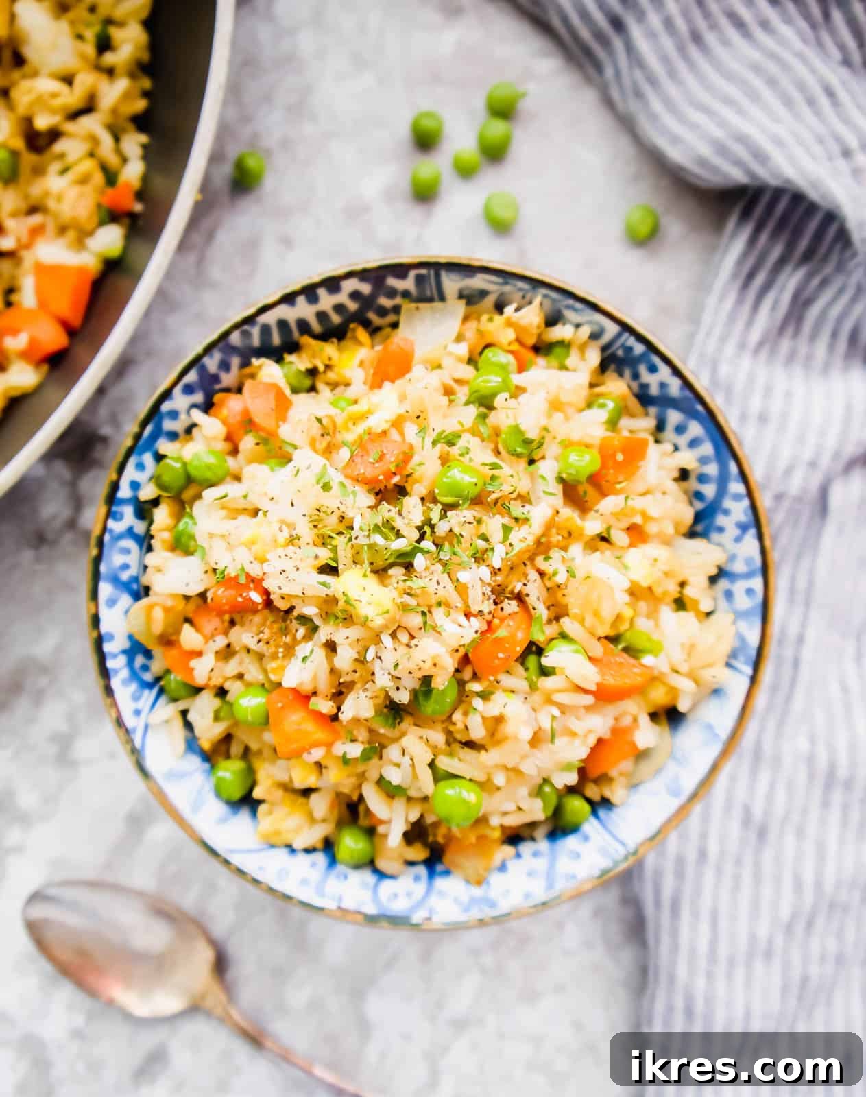 A beautifully presented bowl of coconut aminos fried rice, garnished with fresh green onions and toasted sesame seeds, ready to be enjoyed.