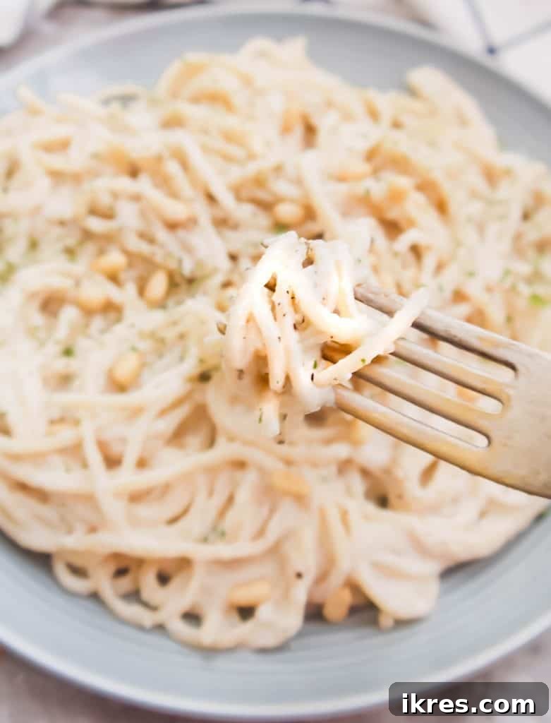 The finished Dairy-Free Cauliflower Pine Nut Sauce poured into a small white bowl, ready to serve.