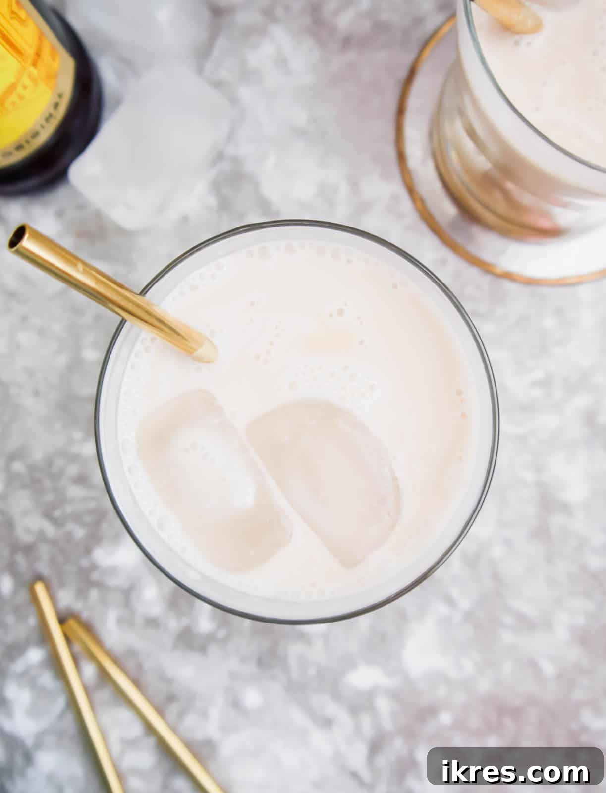 Silken White Russian 3 An aerial view of a Dairy-Free White Russian cocktail in a glass, with visible ice cubes, highlighting its creamy texture.