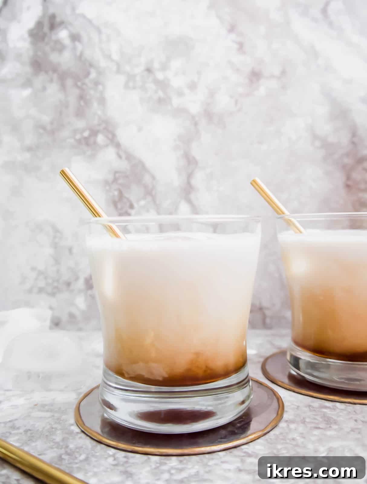 Silken White Russian 5 Two glasses of Dairy-Free White Russian, seen from a side angle, showcasing their inviting creamy appearance.
