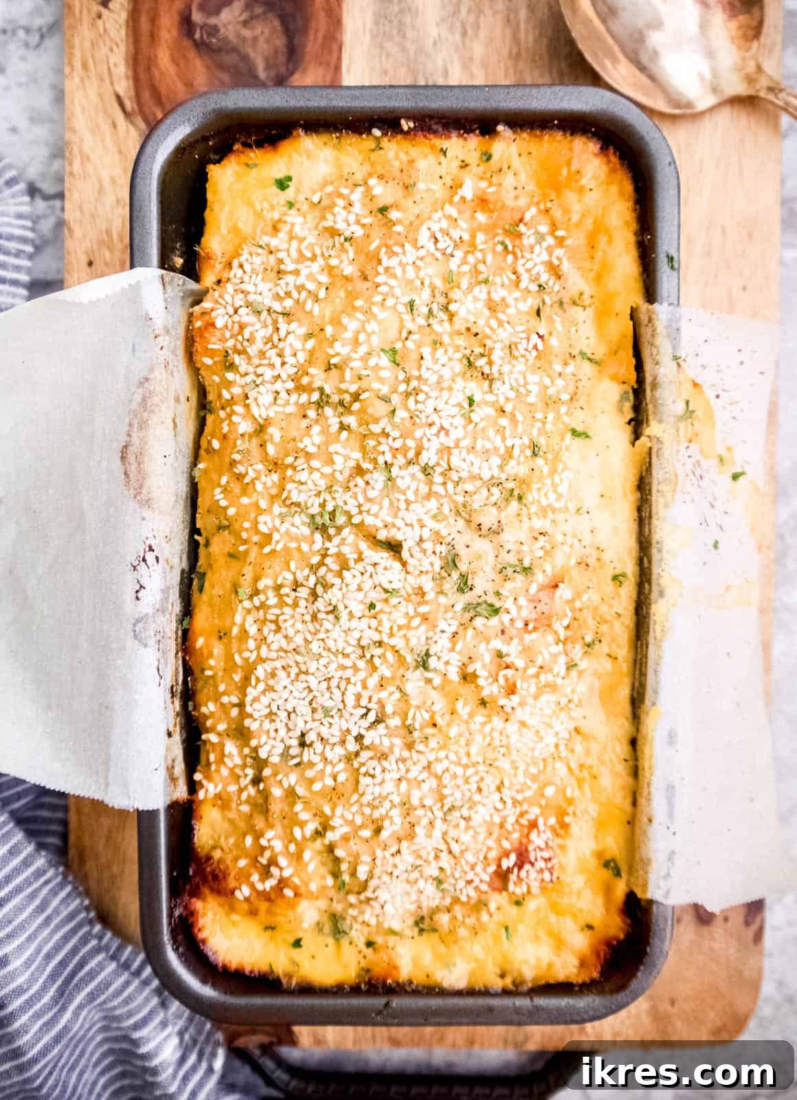 Paleo turkey meatloaf with honey sesame seasoning in a loaf pan, ready for baking.
