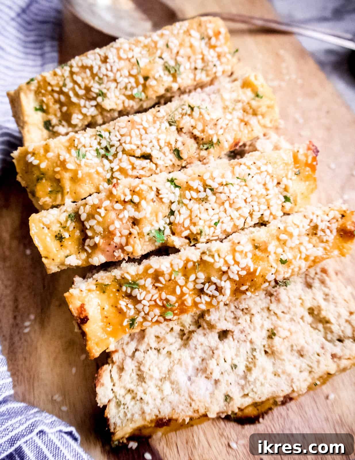 Sliced honey sesame paleo meatloaf on a cutting board, ready to serve.