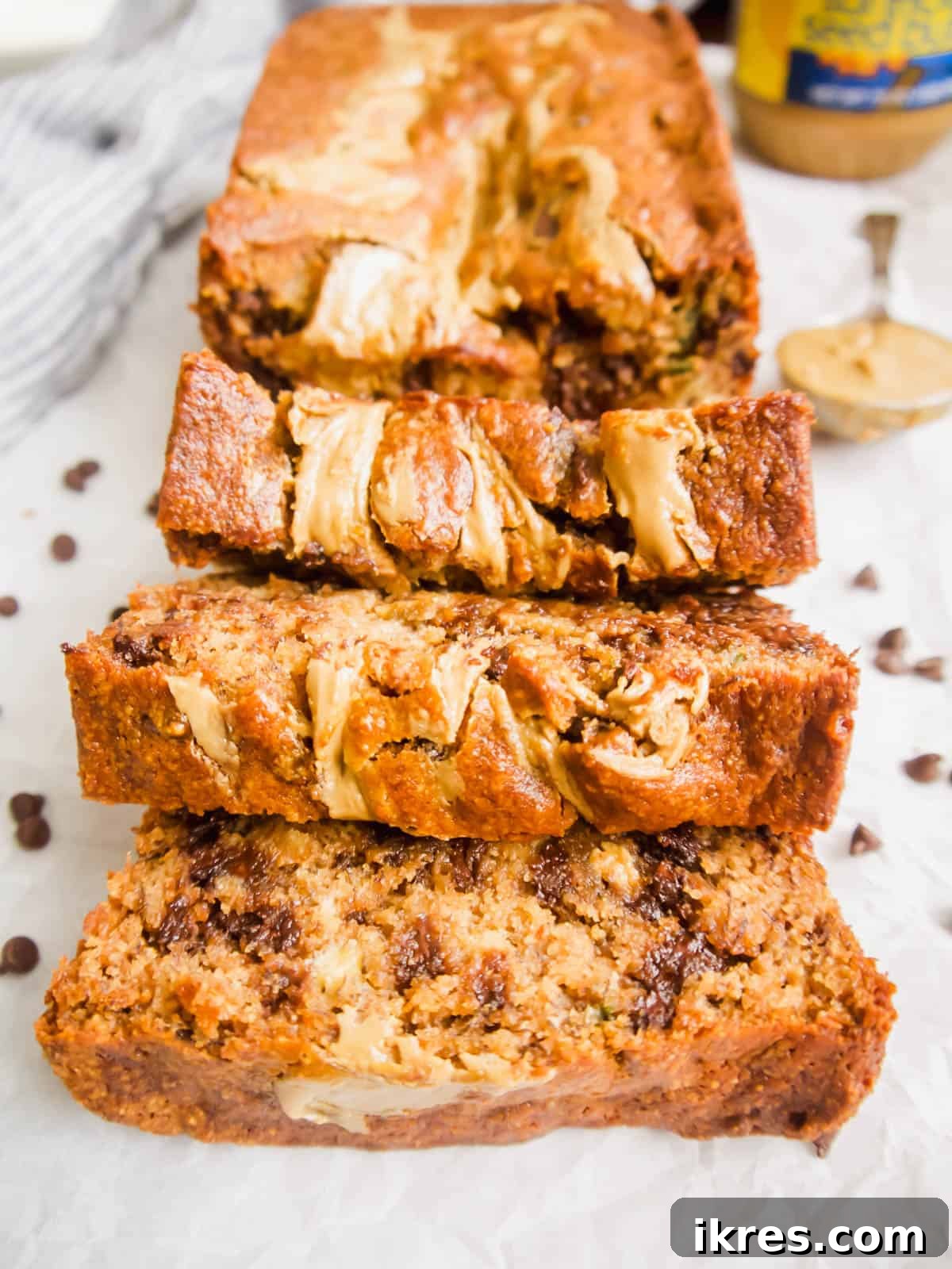 Several slices of Paleo Banana Bread with Sunflower Butter and Chocolate Chips arranged on a wooden board, showcasing the moist interior and swirls.