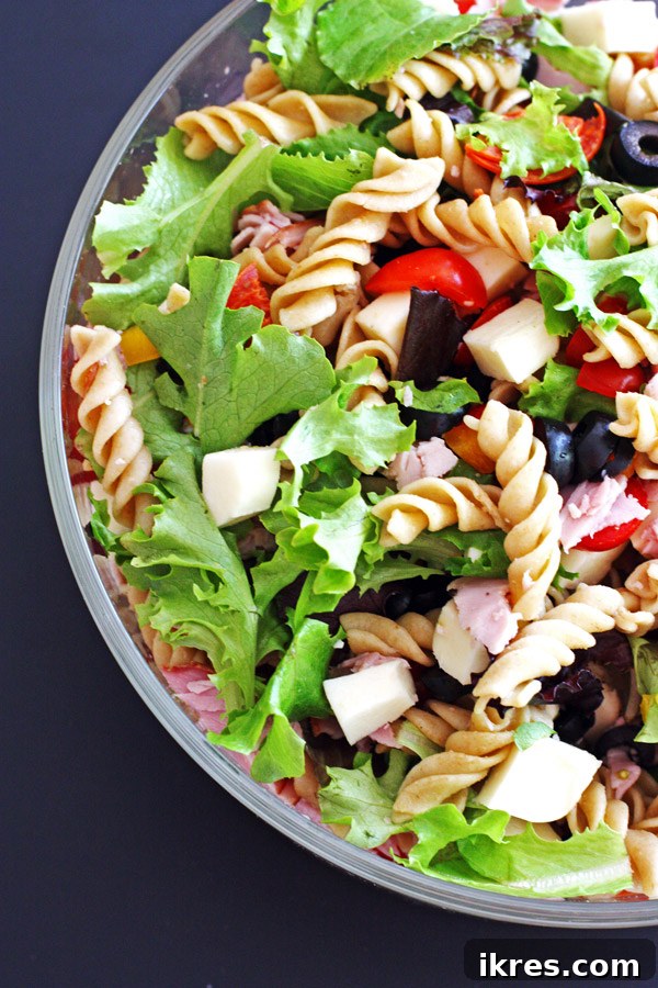 Italian Feast Pasta Salad 3 Delicious Antipasto Pasta Salad with ham, pepperoni, tomatoes, and mozzarella, ideal for dinner.