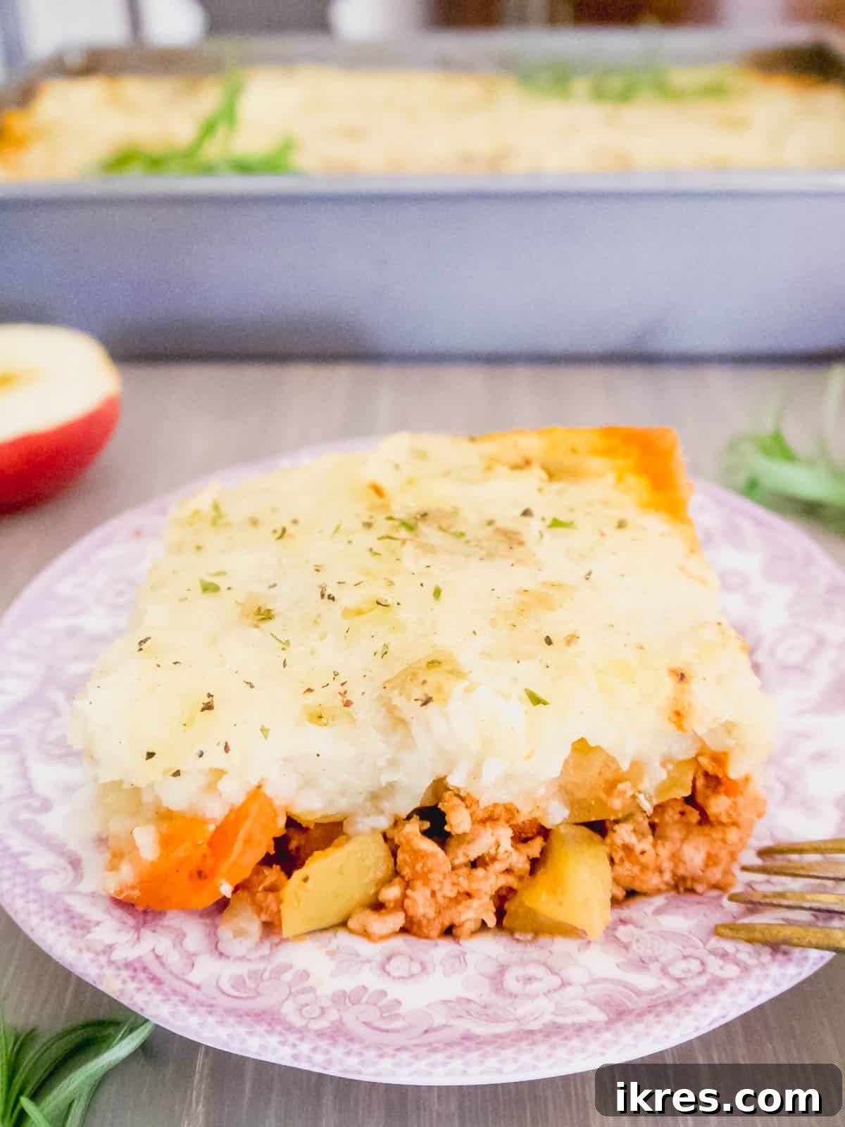 Paleo turkey shepherd's pie artfully arranged on a plate with fresh herbs.