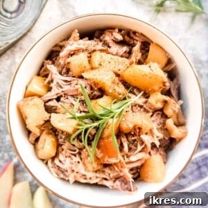 Apple pulled pork in a bowl with cooked apples on top, showcasing the dish from the recipe card.
