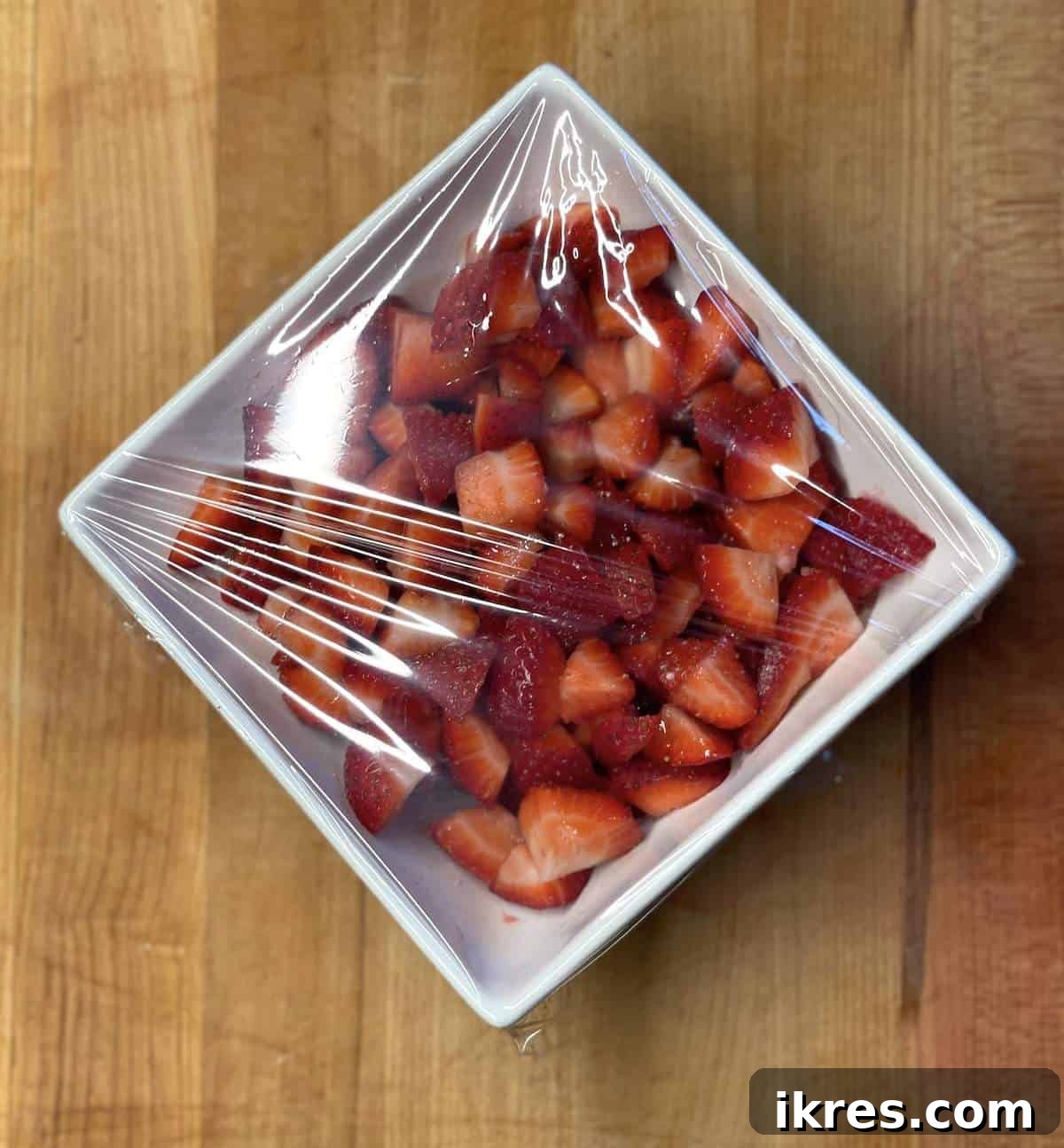 Strawberry Angel Delight 6 A bowl of sugar coated strawberries wrapped in plastic.