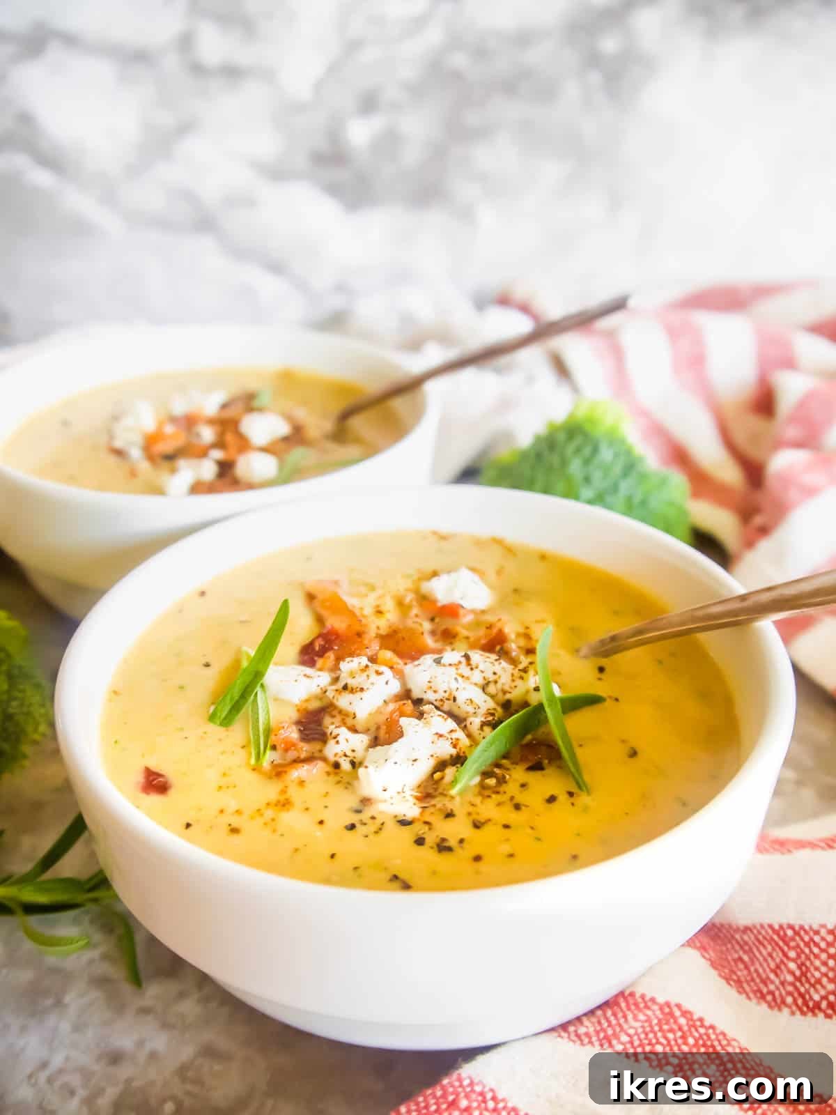 Two cozy bowls of broccoli and sweet potato soup, beautifully garnished with crispy crumbled bacon on top.