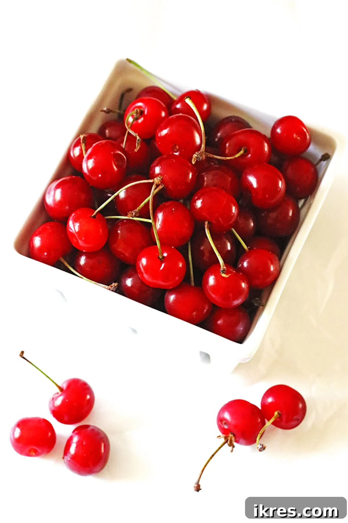 Tropical Cherry Pineapple Bliss 3 A white quart basket brimming with fresh, ripe tart cherries, showcasing their vibrant red color and readiness for culinary use.