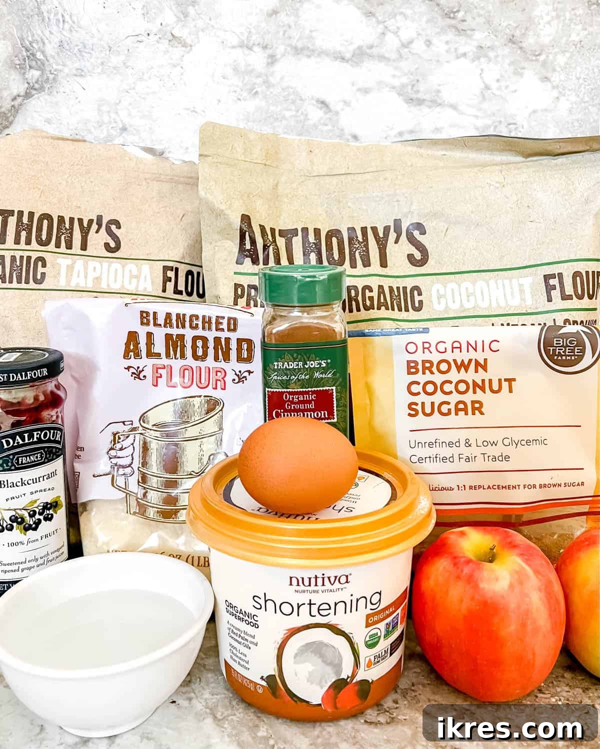 Ingredients needed to make paleo apple tart laid out on a surface.