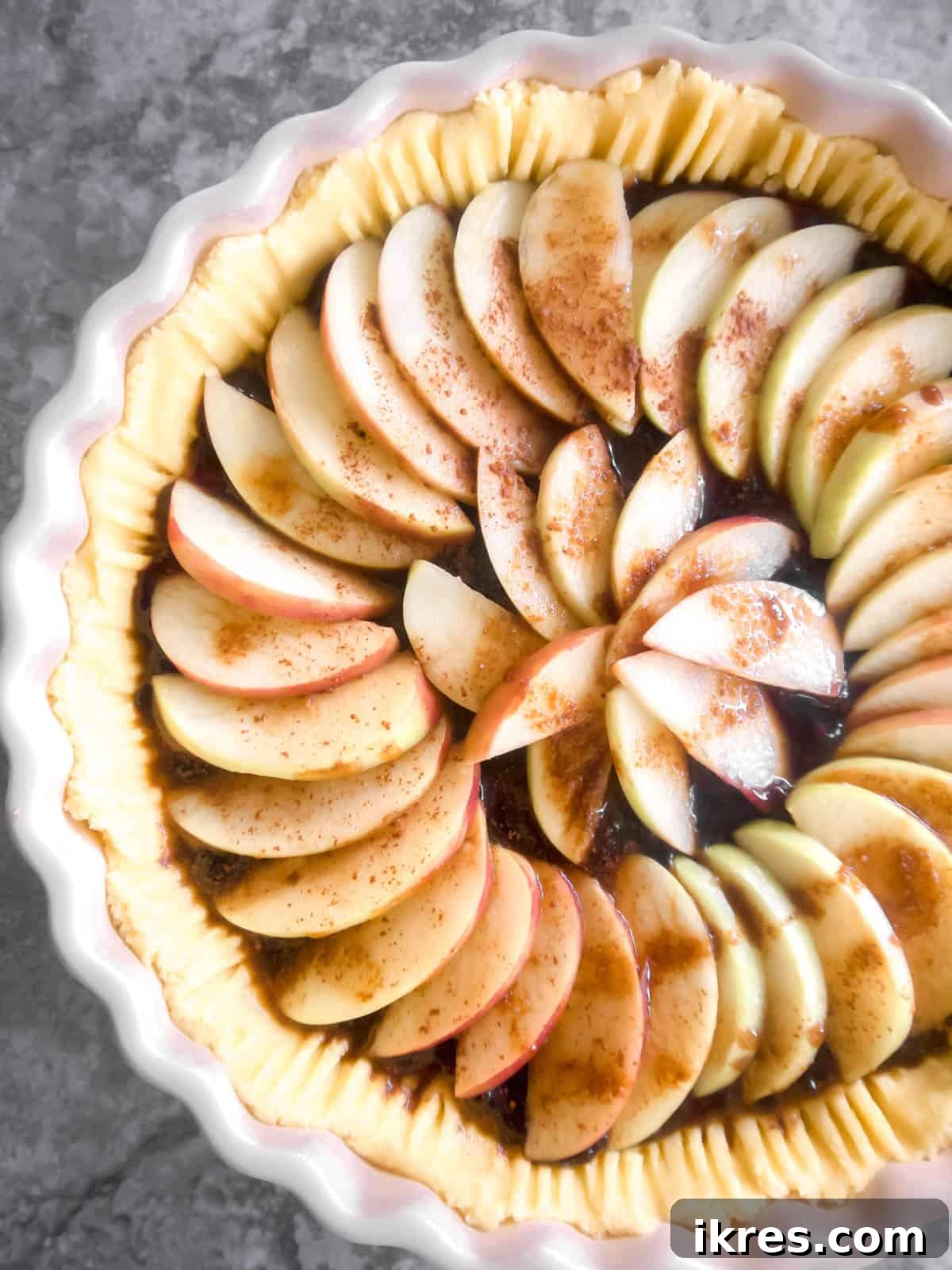 Thinly sliced apples arranged on the tart before baking.
