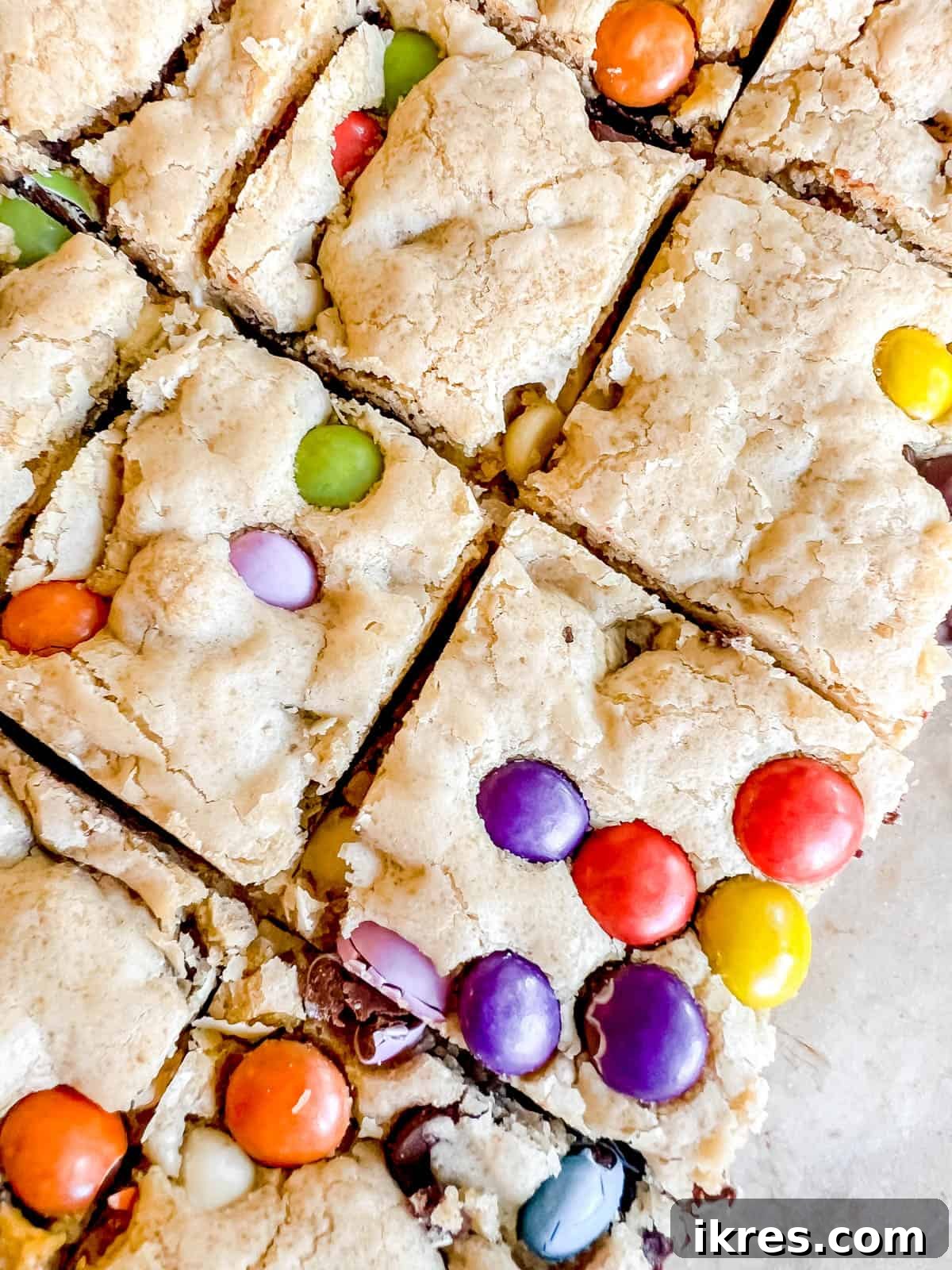 Ultimate Gluten-Free Dairy-Free Chocolate Chip Cookie Bars 11 Gooey chocolate chip cookie bars with chocolate candies inside, ready to be picked up.