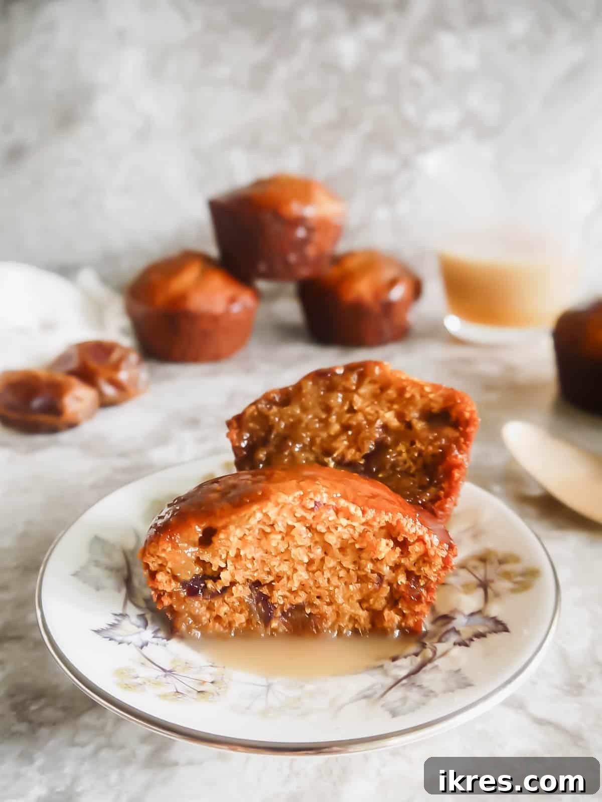 Decadent Gluten-Free Dairy-Free Sticky Toffee Muffins 3 A dairy-free sticky toffee pudding muffin cut in half, revealing its soft, moist crumb and visible pieces of dates.