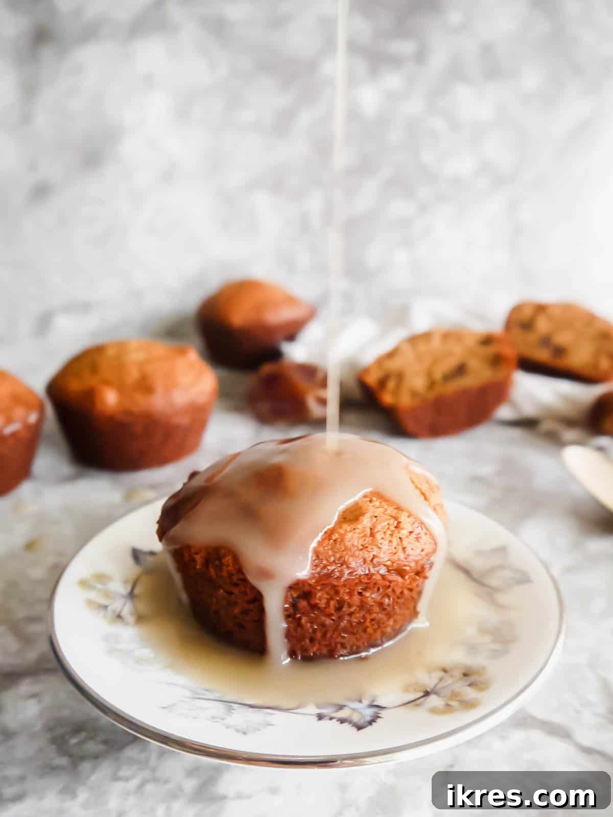 Decadent Gluten-Free Dairy-Free Sticky Toffee Muffins 5 Rich caramel sauce being generously poured on top of a warm Paleo sticky toffee pudding dessert muffin.