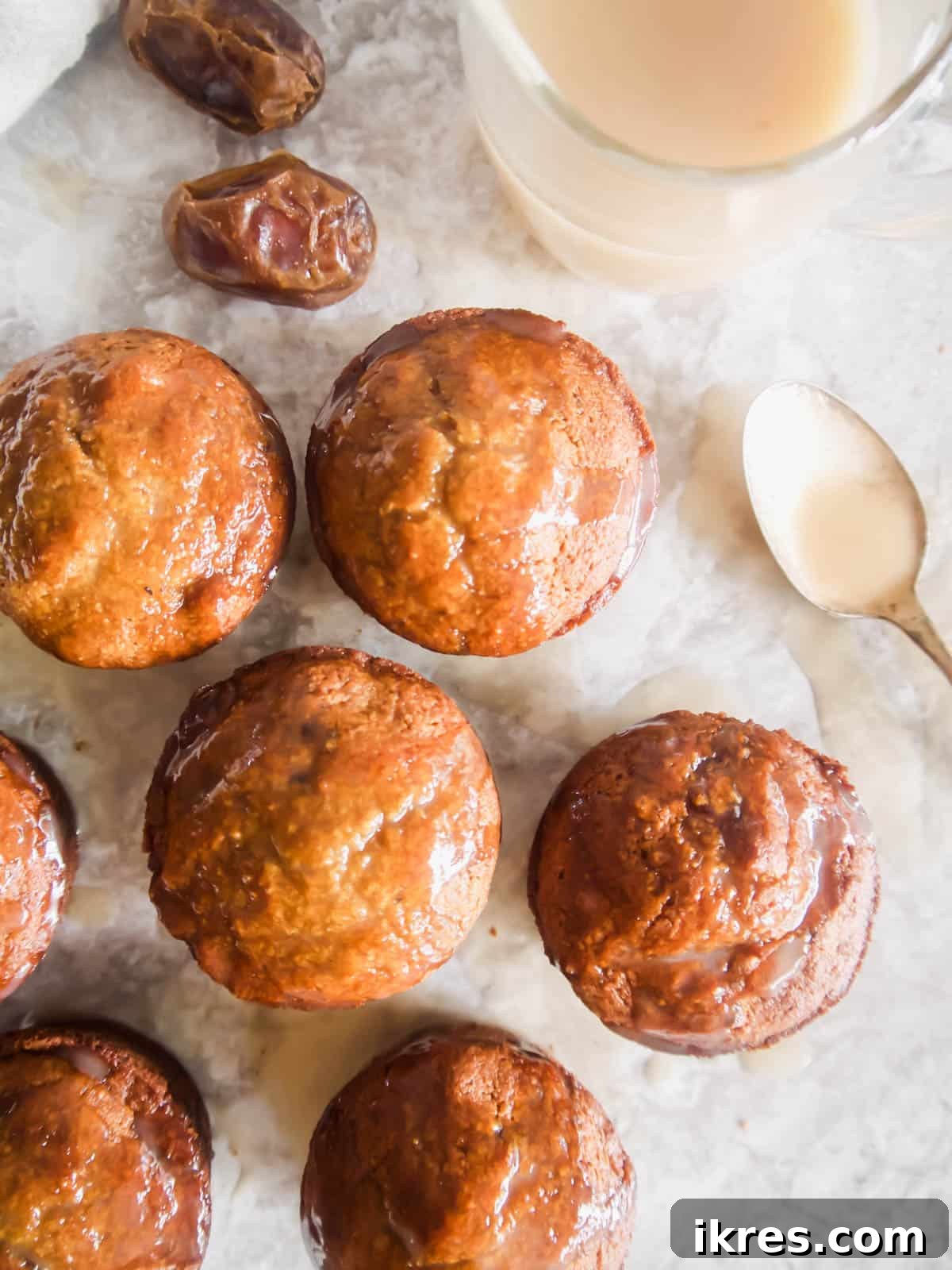 Decadent Gluten-Free Dairy-Free Sticky Toffee Muffins 6 A cluster of Gluten-Free Paleo Sticky Toffee Pudding Muffins on a table, beautifully glistening after being drizzled with caramel sauce.