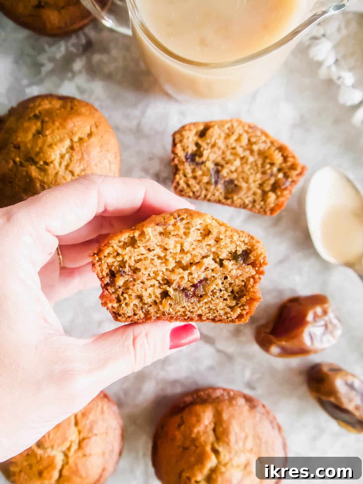 Decadent Gluten-Free Dairy-Free Sticky Toffee Muffins 7 A healthy sticky toffee pudding muffin neatly cut in half, showcasing its inviting texture and moist, date-studded interior.