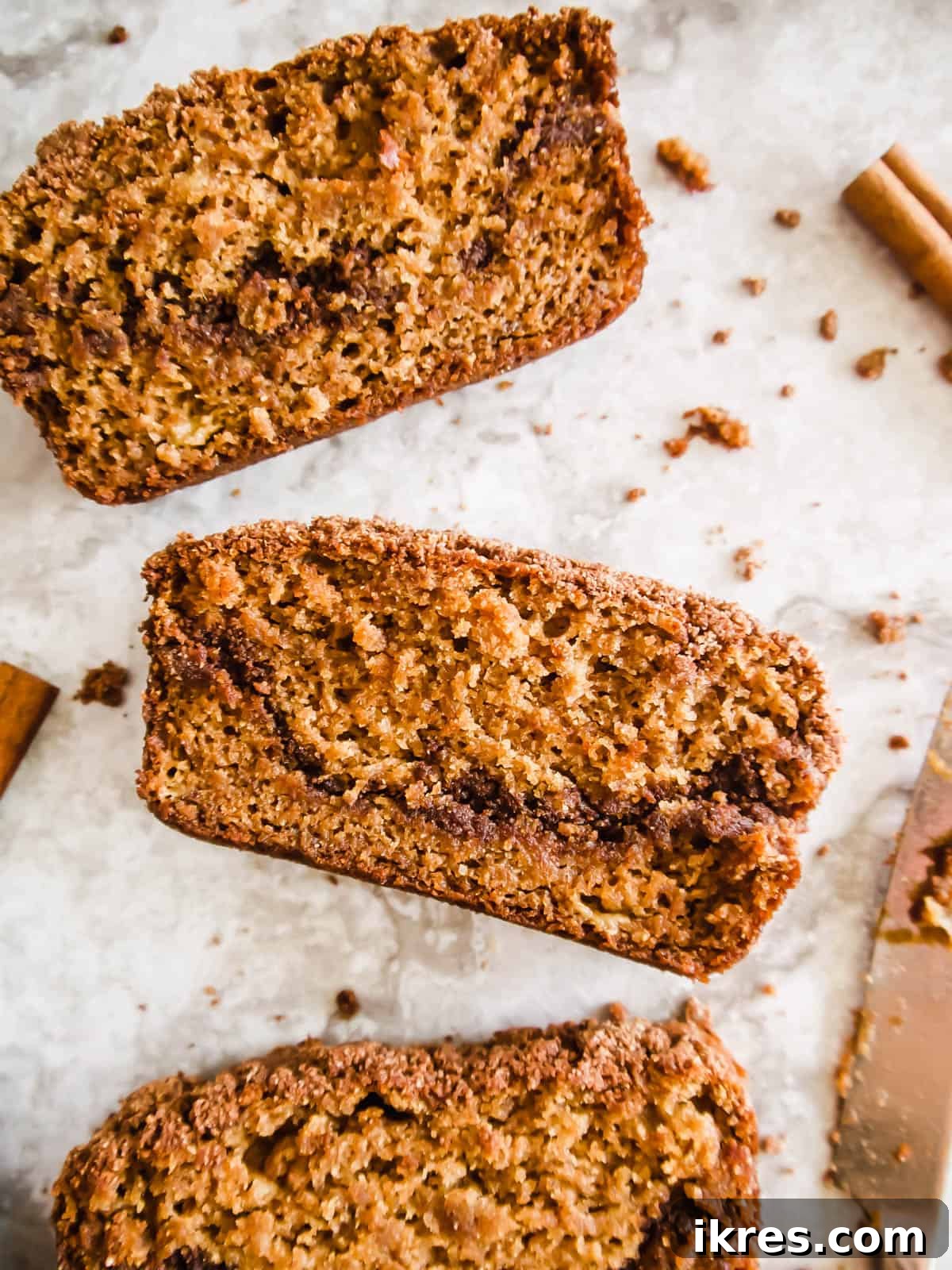 Paleo Gluten-Free Cinnamon Swirl Banana Bread Coffee Cake 3 A beautifully presented slice of paleo coffee cake banana bread on a rustic wooden table.