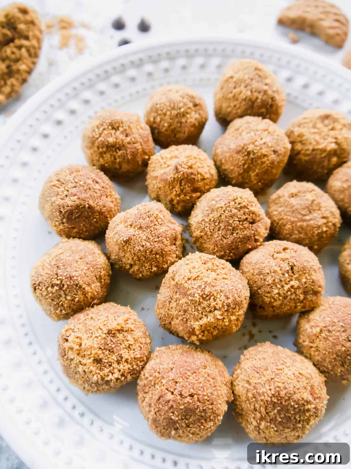 Decadent Gluten-Free Dairy-Free Chocolate Mousse Truffles 4 A close-up side profile of several chocolate mousse balls artfully arranged on a pristine white plate, showcasing their perfectly round shape and rich, crumbly coating.