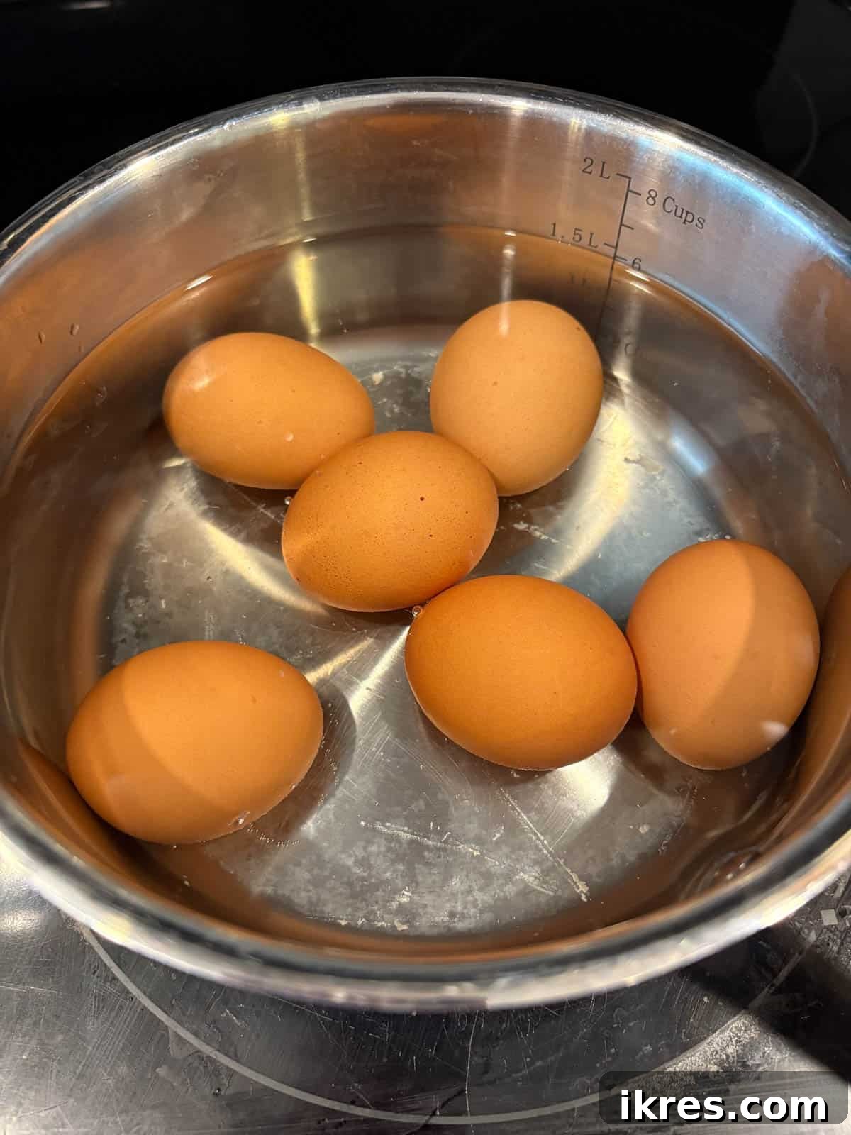 Eggs boiling in a saucepan on the stove.