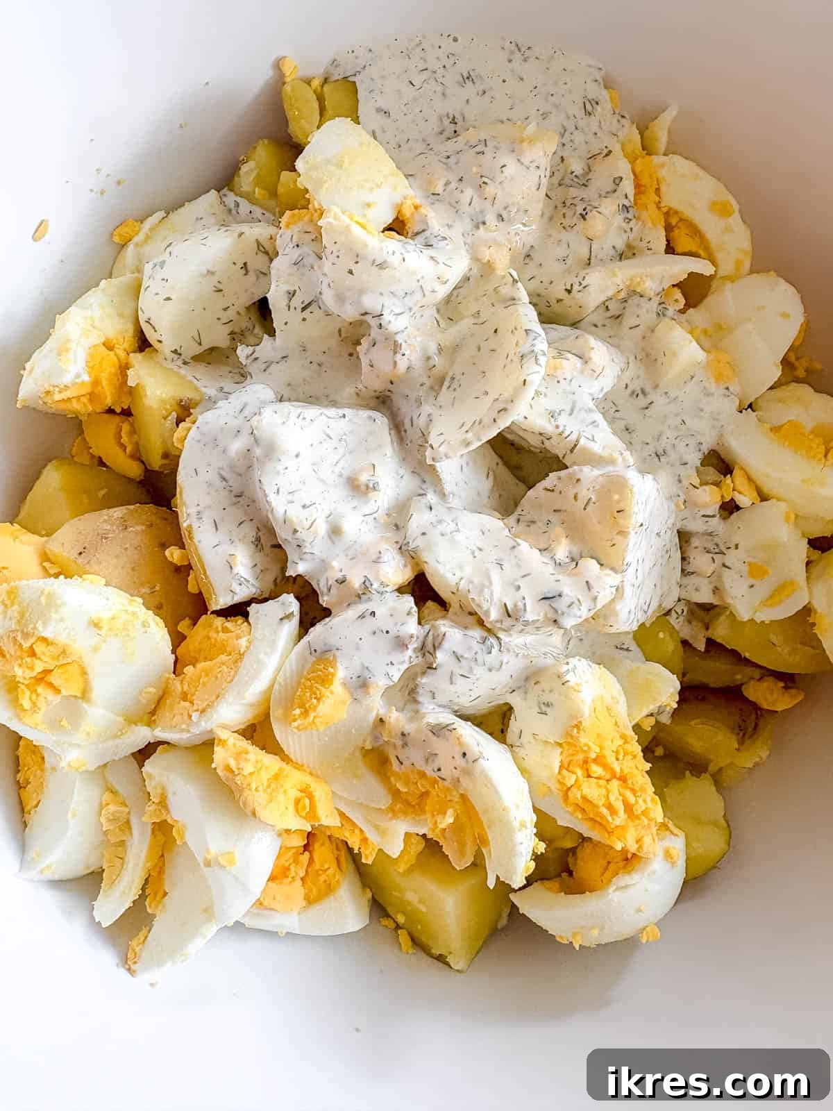 All ingredients for the potato salad in a large bowl, ready for mixing.