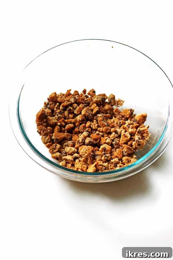 Monster Cookie Dough Dream 4 A clear glass bowl filled with coarsely chopped chocolate chip cookies, showing varying sizes of crumbs and chunks.